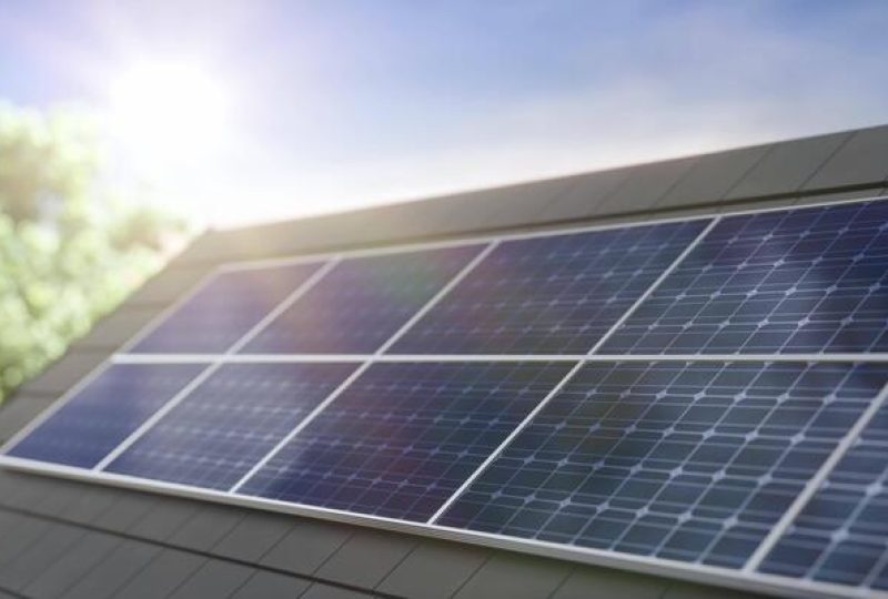 solar-panel-on-a-roof-with-sunlight-and-green-foliage-in-the-background-video